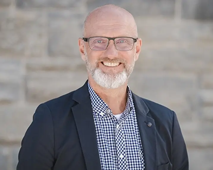 Rainer Tschopp trägt ein blaukariertes Hemd, einen Blazer und ein Lächeln.